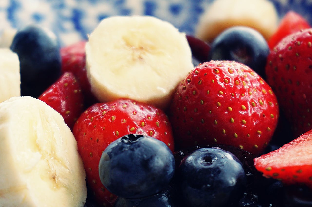 services-01 Close-up of fresh bananas, strawberries, and blueberries. Perfect for health and diet themes.