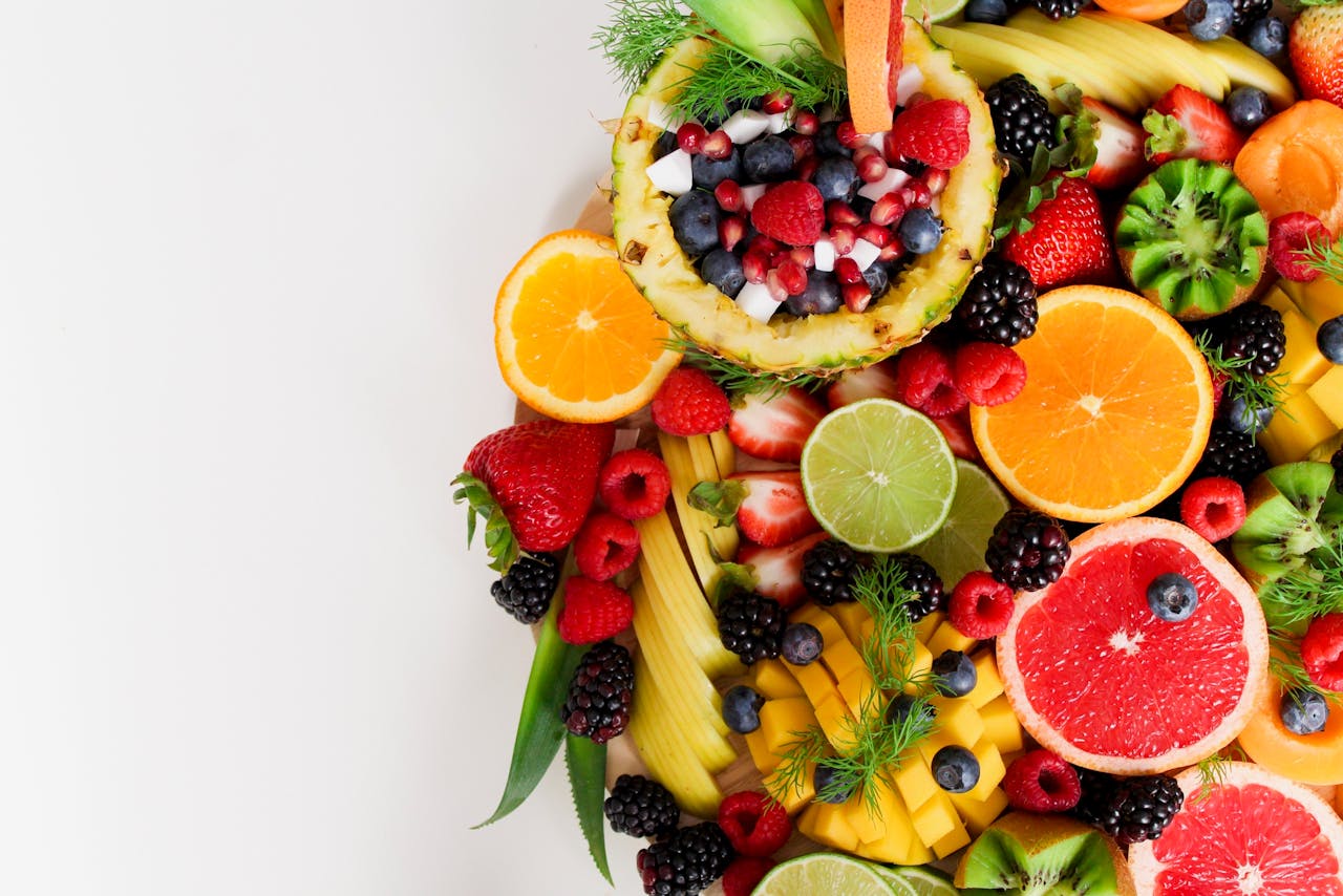 services-03 Colorful flat lay of assorted tropical fruits including pineapple, berries, and citrus.