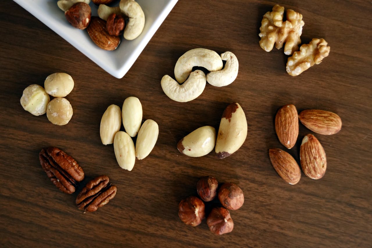 ours-journey Close-up of various nuts on a wooden table, showcasing healthy snacking options.